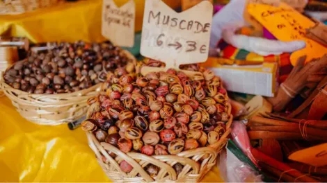 A basket of nutmeg seeds on sale, labeled "Muscade."