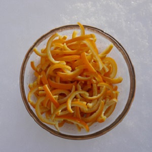 Strips of orange peels in a glass bowl.