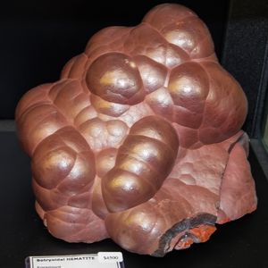 A lustrous, bulbous coral colored kidney ore hematite stone.