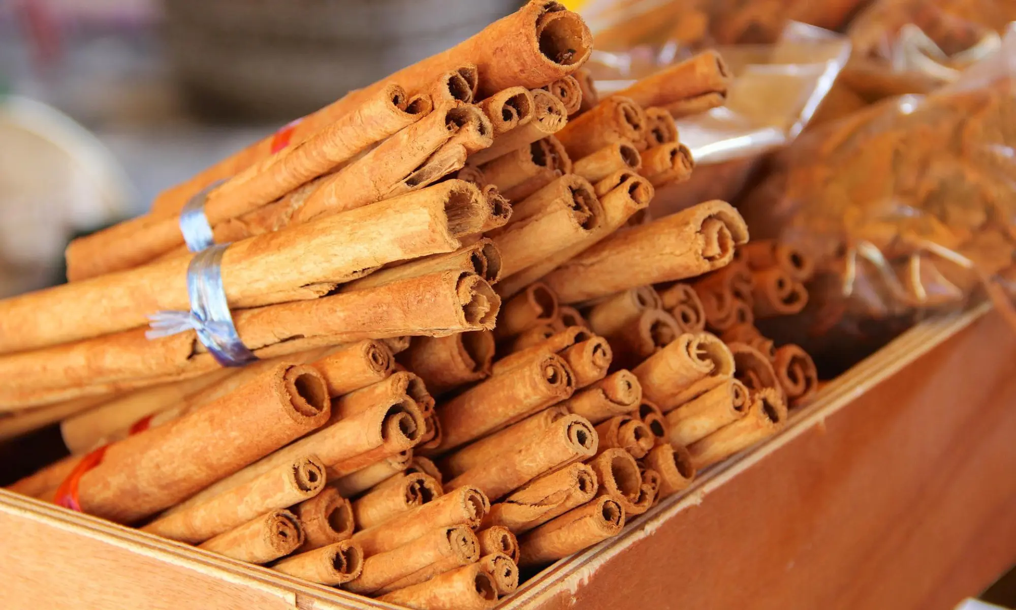 Bundles of cinnamon sticks in a wooden box.