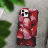 An iPhone 11 Pro sitting near leaves decorated with our Pomegranate Seeds iPhone Case.