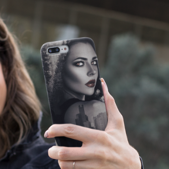 A woman taking a selfie with an iPhone 8 decorated with our Witchy Woman in the City case design.