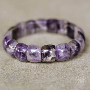 An amethyst beaded bracelet from Conscious Items sitting on a granite surface.