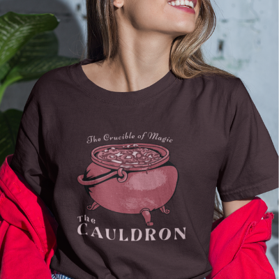 A woman wearing an Oxblood Black Cauldron T-Shirt from Elune Blue on Etsy.