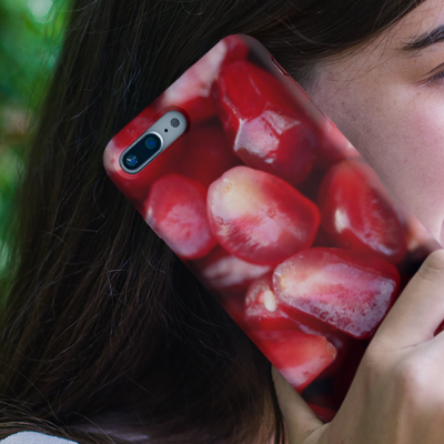 A woman holding an iPhone XS Plus to her ear decorated with our Pomegranate Seeds iPhone Case from Elune Blue on Etsy.