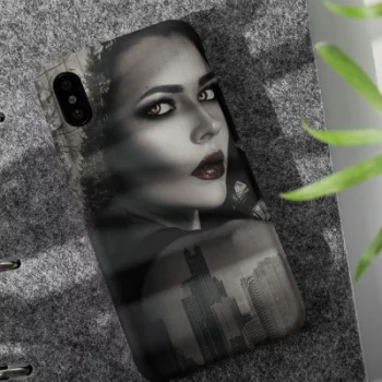 An iPhone 11 case designed with a bewitching woman, sitting on a granite surface near a plant.