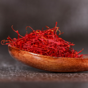 Red Saffron spice on a wooden spoon.
