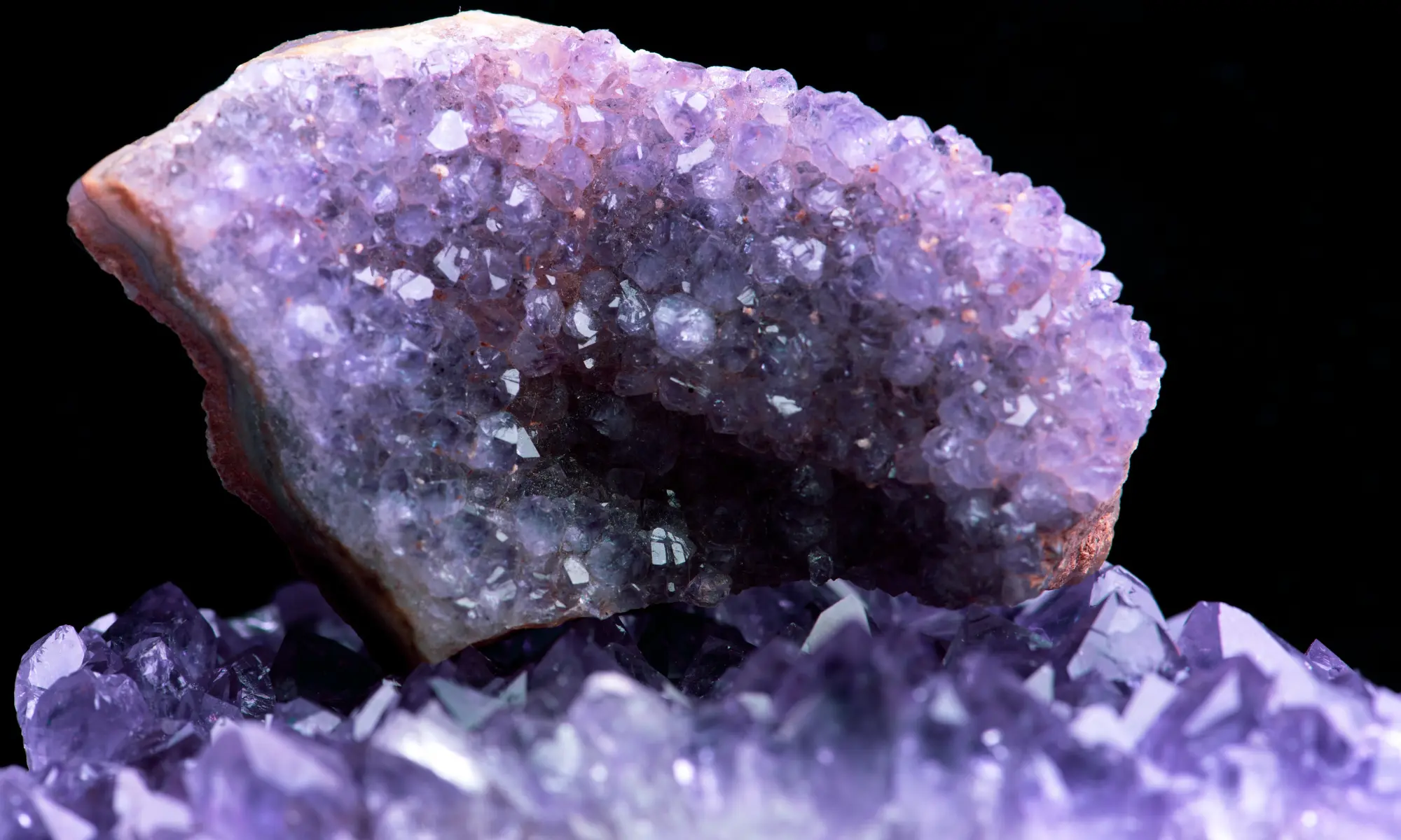 An amethyst crystal geode against a black background.