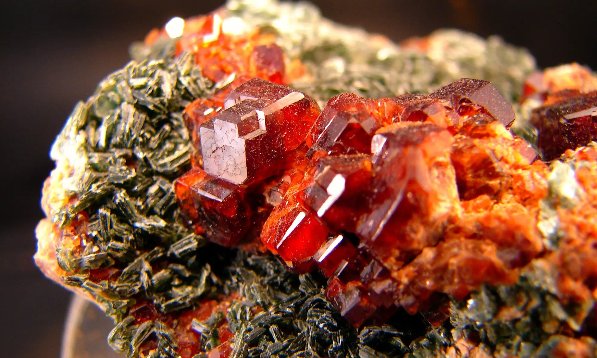 A vibrant red grossular garnet crystal within a matrix,