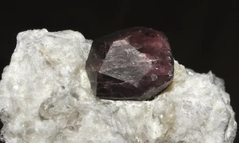A pyrope garnet nugget attached to a clear crystal matrix.