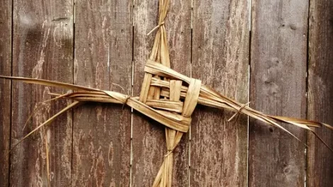 A Brigid's Cross on a wooden table.
