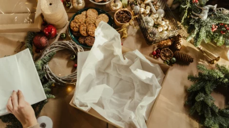 A white paper sheet peeking out of a cardboard box, surrounded by Christmas decorations.