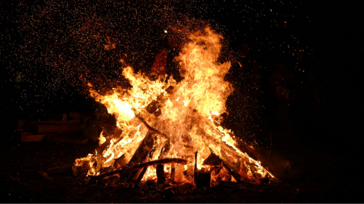 A bonfire burning brightly in the darkness, symbolizing the light and warmth of Imbolc.